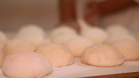 Baker kneading dough with rolling pin on table. Woman rolling dough for pizza. R Stock Footage 90732216