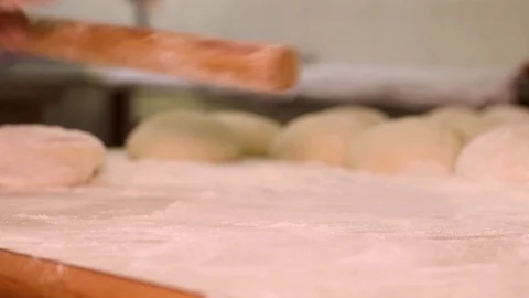 Baker kneading dough with rolling pin on table. Woman rolling dough for pizza. R Stock Footage 90732537