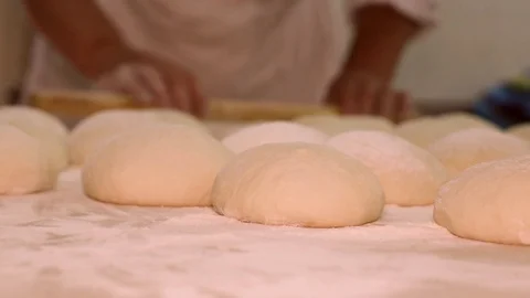 Baker kneading dough with rolling pin on table. Woman rolling dough for pizza. R Stock Footage 90732601