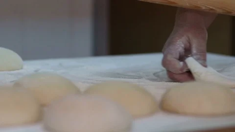 Baker kneading dough with rolling pin on table. Woman rolling dough for pizza. Stock Footage 90733337