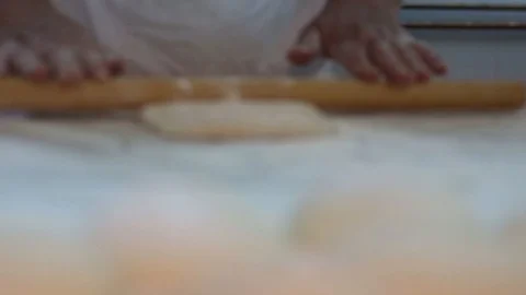 Baker kneading dough with rolling pin on table. Woman rolling dough for pizza. Stock Footage 90733812