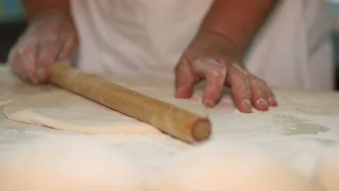 Baker kneading dough with rolling pin on table. Woman rolling dough for pizza. R Stock Footage 90735585