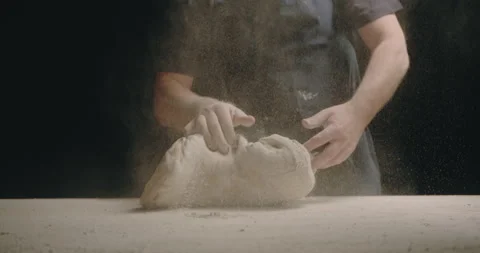 Baker kneading dough under light black background Stock Footage 254958970
