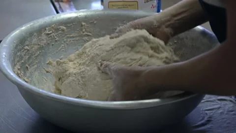 Baker kneads the dough by hands Stock Footage 143584615