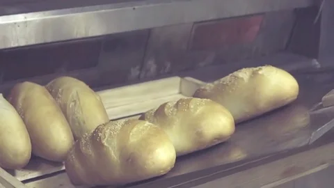 Baker lay out freshly baked bread loaf to tray HD slow-motion bakery video Stock Footage 74727634