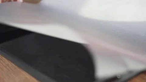 The baker lays the baking paper on a black roast before making the pie. Empty Stock Footage 128949937