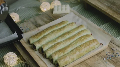 Baker lifting golden pastry tubes from the hot tray Stock Footage 342129142
