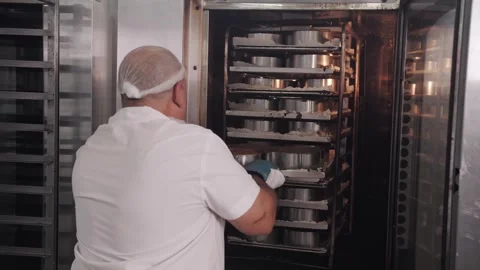 Baker Loading Fresh Muffins Into Industrial Oven, Commercial Kitchen Stock Footage 322019078
