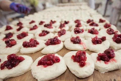 Baker make buns with fruit filling from dough Stock Photos