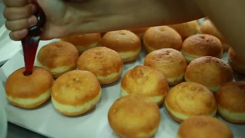 Baker makes deep-dried Sufganiyah for the Jewish festival of Hanukkah. Stock Footage 116414689