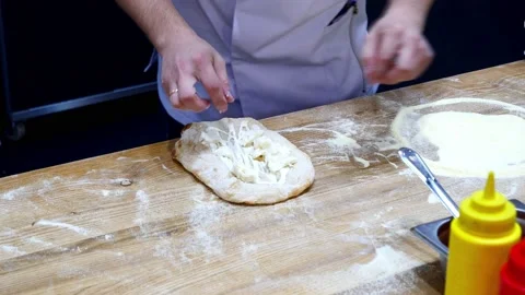 The baker makes a Georgian cheese flatbread Stock Footage 232578135