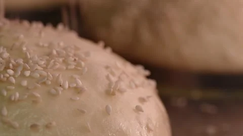 Baker makes a loaf of bread from the dough. Chef baker sprinkles sesame seeds on Stock Footage 152930084