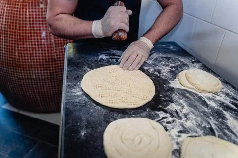 Baker makes pattern on blank for Uzbek flatbread Stock Photos