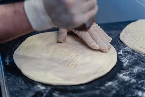 Baker makes pattern on blank for Uzbek flatbread Stock Photos