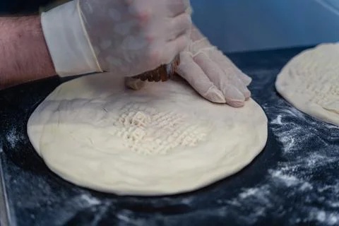 Baker makes pattern on blank for Uzbek flatbread Stock Photos