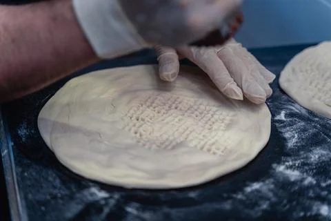 Baker makes pattern on blank for Uzbek flatbread Stock Photos