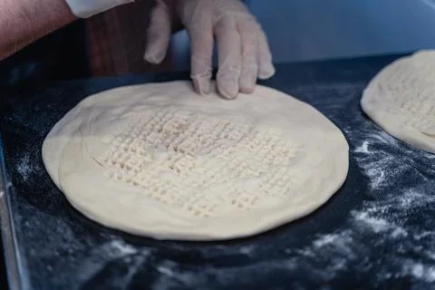 Baker makes pattern on blank for Uzbek flatbread Stock Photos