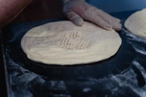 Baker makes pattern on blank for Uzbek flatbread Stock Photos