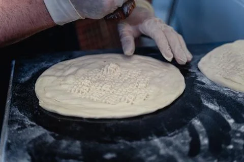 Baker makes pattern on blank for Uzbek flatbread Stock Photos