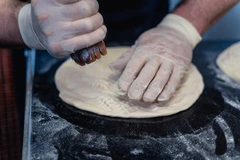 Baker makes pattern on blank for Uzbek flatbread Stock Photos