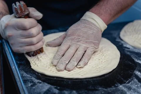 Baker makes pattern on blank for Uzbek flatbread Stock Photos