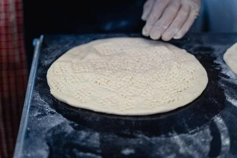 Baker makes pattern on blank for Uzbek flatbread Stock Photos