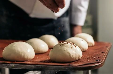 Baker making bread at a bakery. Stock Photos