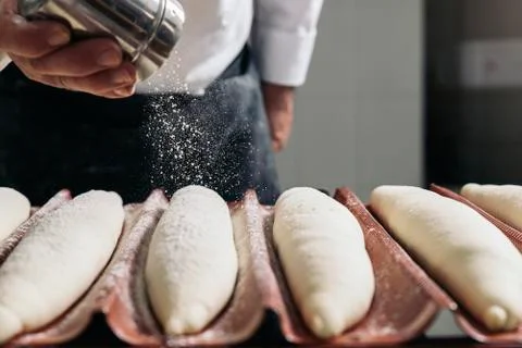 Baker making bread at a bakery. Stock Photos