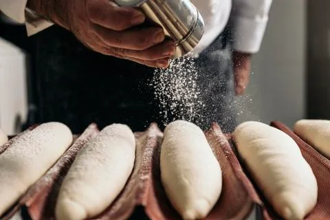Baker making bread at a bakery. Stock Photos