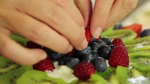 A baker making a fresh berry fruit tart desert Stock Footage 40479616