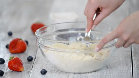 Baker is making a shortbread dough. Adding egg to flour making a dough. Video stock 117035724