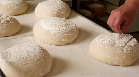 Baker making traditional pattern on the raw ball dough bread Stock Footage 64471061
