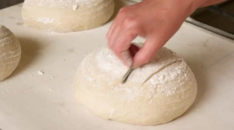 Baker making traditional pattern on the raw ball dough bread Stock Footage 64471068