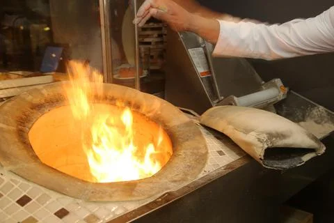 Baker making Turkish pita bread in tandoor Stock Photos
