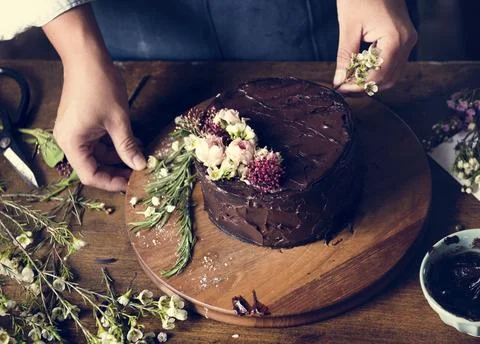 Baker Man Decorating Chocolate Cake with Flowers Stock Photos