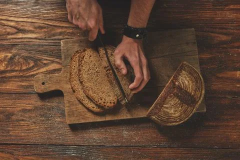 Baker man slices bread Stock-Fotos