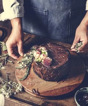 Baker Man Using Flowers Decorating Chocolate Cake Stock Photos