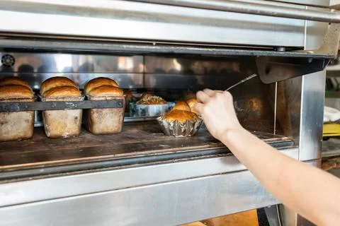 The baker measures the temperature inside the Stock Photos