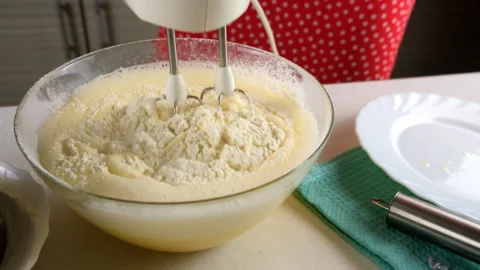 Baker mixing flour into batter with electric mixer cooking biscuit dough. Stock Footage 311528523