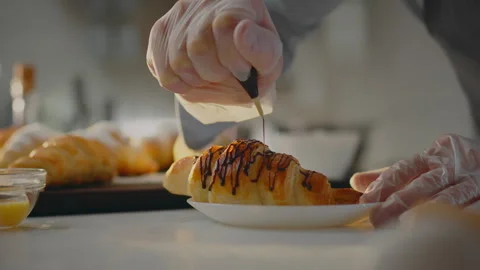 Baker. A modern chef dressed in protective gloves concentrates pouring fresh Stock Footage 271149382