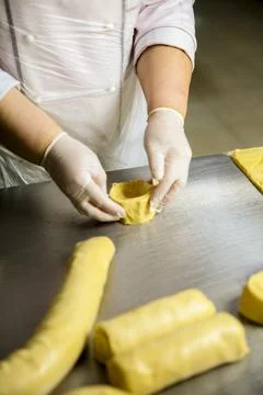 Baker molds dough into shape in a kitchen setting Stock Photos