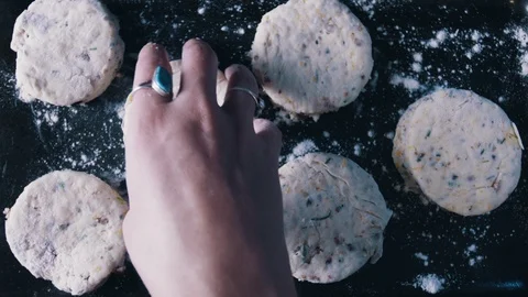 Baker moving biscuits on metal pan with flour sprinkle in kitchen Stock Footage 117950158
