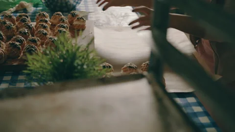 Baker moving finished profiteroles onto a tray Stock Footage 274649677