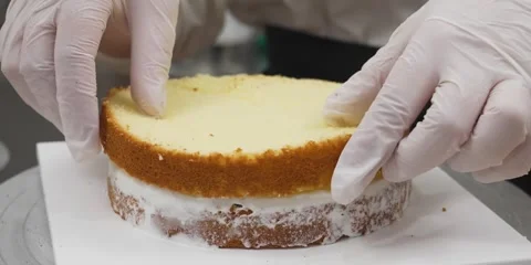 Baker Placing Layer of Sponge Cake During Assembly 動画素材 343588423