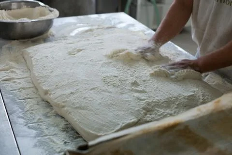 Baker Placing Raw Ciabatta Bread on Tray Stock Photos