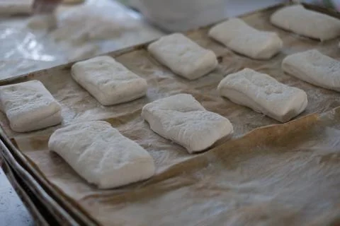 Baker Placing Raw Ciabatta Bread on Tray Stock Photos