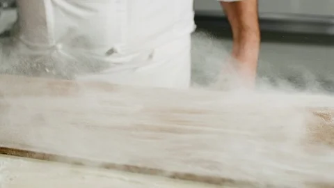 A baker placing the yeast-raised bread on the work surface sprinkled with flour Stock Footage 86864273