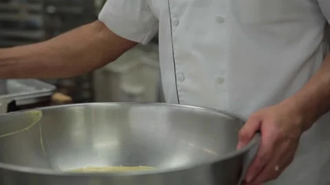 A baker pours eggs into a cake mixture Stock Footage 231415064