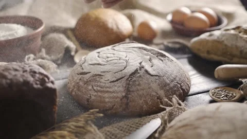 The baker pours flour onto the fresh bread. Pastries and bakery products. Stock Footage 156953603