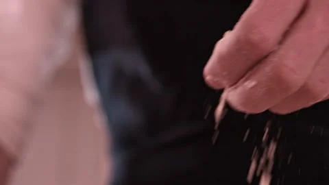 Baker pours flour in kitchen. Baker sprinkles pinch of flour on baking Video stock 151118921